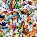 Vibrant assortment of medicine capsules and tablets in a flatlay format, highlighting diversity in pharmaceuticals.